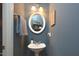 Charming half-bathroom featuring a pedestal sink, decorative mirror, and modern wall color at 5 Burgess Ct, Hillsborough, NC 27278