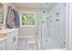 Bright bathroom showcasing a glass enclosed shower with tiled walls, vanity, and a window for natural light at 5 Burgess Ct, Hillsborough, NC 27278