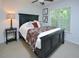 Bedroom featuring a dark wood bed frame, floral bedding, and ample natural light from the window at 5 Burgess Ct, Hillsborough, NC 27278