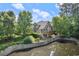 Backyard featuring a pond and a deck, framed by mature trees and lush greenery at 51 Abernathy Dr, Chapel Hill, NC 27517