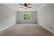 Cozy bedroom with neutral carpet and a window offering a view of lush greenery at 51 Abernathy Dr, Chapel Hill, NC 27517