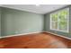 A vacant bedroom featuring hardwood floors, ample natural light from a window, and neutral wall color at 51 Abernathy Dr, Chapel Hill, NC 27517