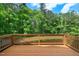 Spacious wooden deck with railing, surrounded by lush greenery and trees, providing a serene outdoor space at 51 Abernathy Dr, Chapel Hill, NC 27517