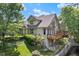 Charming exterior of a multi-story home with a deck overlooking a lush green yard and tranquil pond at 51 Abernathy Dr, Chapel Hill, NC 27517