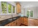 Kitchen featuring stainless steel sink, black countertops, and wooden cabinets at 51 Abernathy Dr, Chapel Hill, NC 27517