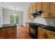 Kitchen featuring a black gas range, wooden cabinets, and hardwood floors at 51 Abernathy Dr, Chapel Hill, NC 27517