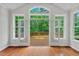 Bright room with hardwood floors leading to an outdoor deck, framed by large windows and French doors at 51 Abernathy Dr, Chapel Hill, NC 27517