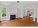 Open living room featuring hardwood floors, a fireplace, and elegant columns leading to the entryway and staircase at 51 Abernathy Dr, Chapel Hill, NC 27517