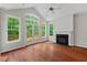 Sunlit living area with a fireplace, hardwood floors, and French doors leading to an outdoor deck at 51 Abernathy Dr, Chapel Hill, NC 27517