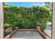 View of the outdoor patio with a brick retaining wall and black fence, surrounded by lush greenery at 51 Abernathy Dr, Chapel Hill, NC 27517