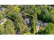 A serene home nestled within a property line surrounded by lush greenery and tall trees from an aerial perspective at 512 Stratford Dr, Zebulon, NC 27597