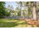 Large backyard with a fenced-in area surrounded by mature trees and lush greenery at 512 Stratford Dr, Zebulon, NC 27597