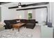 Bright living room with large sectional sofa, modern patterned rug and ceiling fan at 512 Stratford Dr, Zebulon, NC 27597