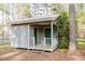 Charming outbuilding with dual green doors and a small porch, perfect for a workshop or storage at 512 Stratford Dr, Zebulon, NC 27597