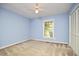 Bright bedroom with blue walls, carpet, a ceiling fan, and a window overlooking the property at 5319 Memory Ln, Durham, NC 27712