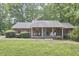 Charming single-story brick home with red shutters and a spacious front lawn with mature trees at 5319 Memory Ln, Durham, NC 27712
