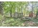 Storage shed with a picnic table surrounded by luscious greenery in a backyard wooded setting at 5319 Memory Ln, Durham, NC 27712