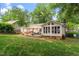 Sprawling backyard with a deck, a sunroom, and lush green grass, perfect for entertaining at 5709 Lakehaven Dr, Raleigh, NC 27612