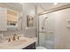 Well lit bathroom with glass-enclosed shower, modern fixtures, and a floating shelf with wall art at 5709 Lakehaven Dr, Raleigh, NC 27612