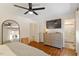 This bedroom boasts sleek ceiling fan, a dresser with flatscreen, and a stylish arched mirror at 5709 Lakehaven Dr, Raleigh, NC 27612