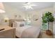 Bright bedroom featuring a queen bed with decorative pillows and a leafy green potted plant at 5709 Lakehaven Dr, Raleigh, NC 27612