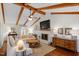Cozy living room with vaulted ceilings, wood beams, a fireplace, and comfortable seating at 5709 Lakehaven Dr, Raleigh, NC 27612