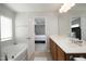 A bright bathroom featuring a soaking tub, double sink vanity, and view to the bedroom at 621 Childsberg Way, Hillsborough, NC 27278