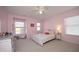 Charming bedroom with a white metal bed frame, pastel bedding, and three windows at 621 Childsberg Way, Hillsborough, NC 27278