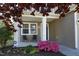 Inviting front porch featuring a black door, seating and lovely flowering shrubbery at 621 Childsberg Way, Hillsborough, NC 27278