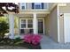 Inviting front porch featuring a black door, seating and lovely flowering shrubbery at 621 Childsberg Way, Hillsborough, NC 27278