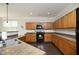 Spacious kitchen with wooden cabinetry, granite countertops, a black stove and stainless steel sink at 621 Childsberg Way, Hillsborough, NC 27278