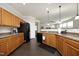 Well-lit kitchen with stainless steel sink, black refrigerator and appliances, and dark wood floors at 621 Childsberg Way, Hillsborough, NC 27278