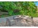 Inviting backyard featuring a gravel patio with seating, a shade umbrella, and mature trees at 623 Massey Ave, Durham, NC 27701