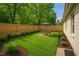 Lush backyard featuring a dining set, well-manicured lawn, and a wooden privacy fence at 623 Massey Ave, Durham, NC 27701
