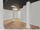 Spacious finished basement with wood-look floors, white walls, dark ceiling, and support beams at 623 Massey Ave, Durham, NC 27701