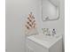 Bright white bathroom with modern vanity, framed mirror, stylish fixtures and patterned hand towel at 623 Massey Ave, Durham, NC 27701