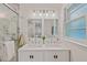 Bright bathroom featuring a double sink vanity, decorative mirror, and modern light fixture at 623 Massey Ave, Durham, NC 27701
