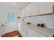 Bright kitchen boasts white cabinets, stainless appliances, and exterior access at 623 Massey Ave, Durham, NC 27701