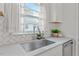 Bright kitchen features white cabinets, subway tile backsplash, and a stainless steel sink at 623 Massey Ave, Durham, NC 27701