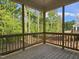 A wood frame back porch with wood rails and view of trees at 629 Conover Rd, Durham, NC 27703