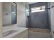 Well-lit bathroom with a gray-tiled shower and sleek vanity, creating a modern aesthetic at 629 Conover Rd, Durham, NC 27703