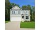 Charming two-story home with a two-car garage, manicured lawn, and beautiful landscaping at 629 Conover Rd, Durham, NC 27703