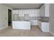 Bright kitchen featuring white cabinets, a center island, and ample storage space at 629 Conover Rd, Durham, NC 27703