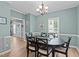 Bright dining room with a stylish chandelier, large windows, and seating for six at 6509 Virgilia Ct, Raleigh, NC 27616