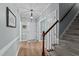 Entryway featuring hardwood floors, neutral paint, decorative trim, and a staircase to the upper level at 6509 Virgilia Ct, Raleigh, NC 27616