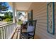 A cozy front porch with comfortable seating, decorative pillows, and a charming 