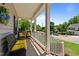 Spacious front porch with comfortable wicker seating, a view of the street, and classic white railings at 6509 Virgilia Ct, Raleigh, NC 27616