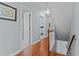 Hallway with hardwood floors leads to bedrooms and stairs with natural light at 6509 Virgilia Ct, Raleigh, NC 27616