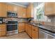 Well-equipped kitchen boasts granite counters, stainless appliances, wood cabinets, and tile backsplash at 6509 Virgilia Ct, Raleigh, NC 27616