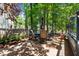 Cozy patio seating area with table and chairs, shaded by mature trees in a private backyard at 6509 Virgilia Ct, Raleigh, NC 27616